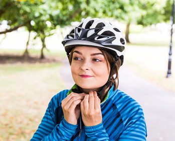 Woman cyclist clipping helmet
