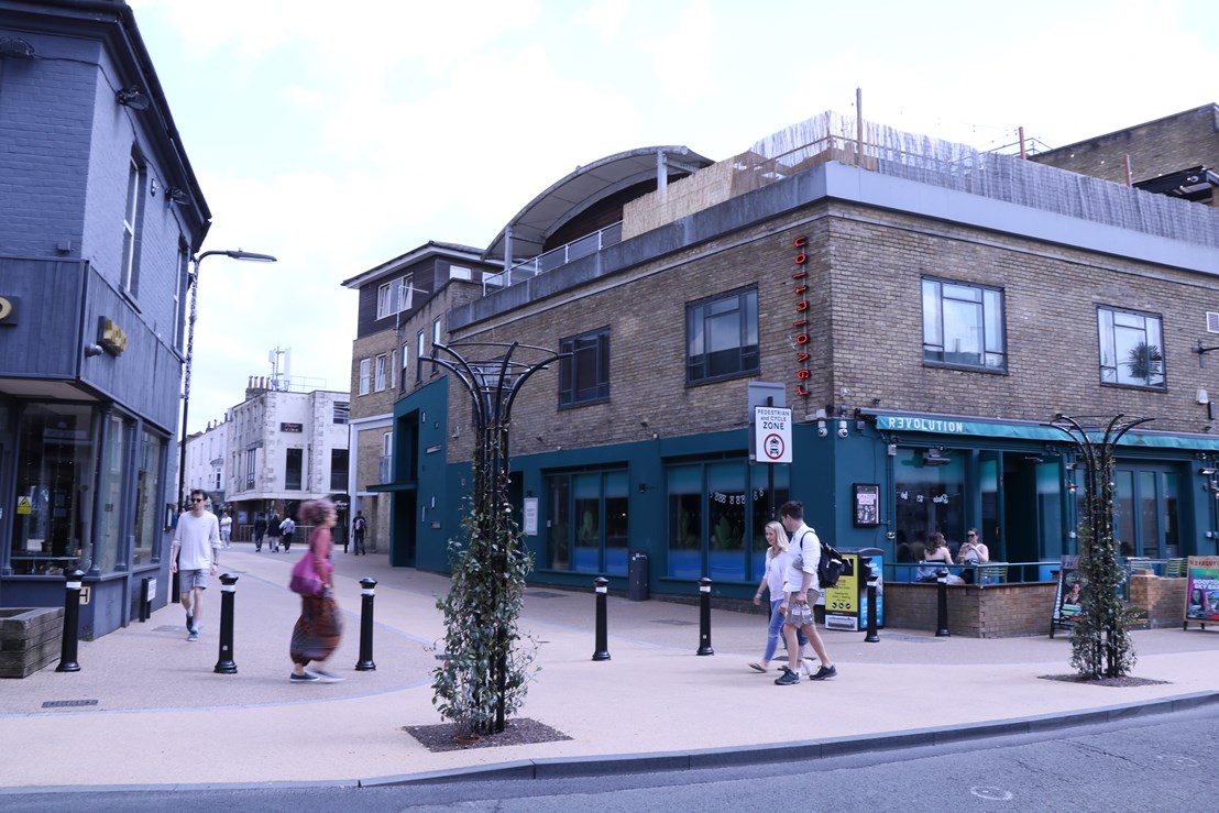 People walking on curved buildout at junction of Bedford Place and Carlton Place